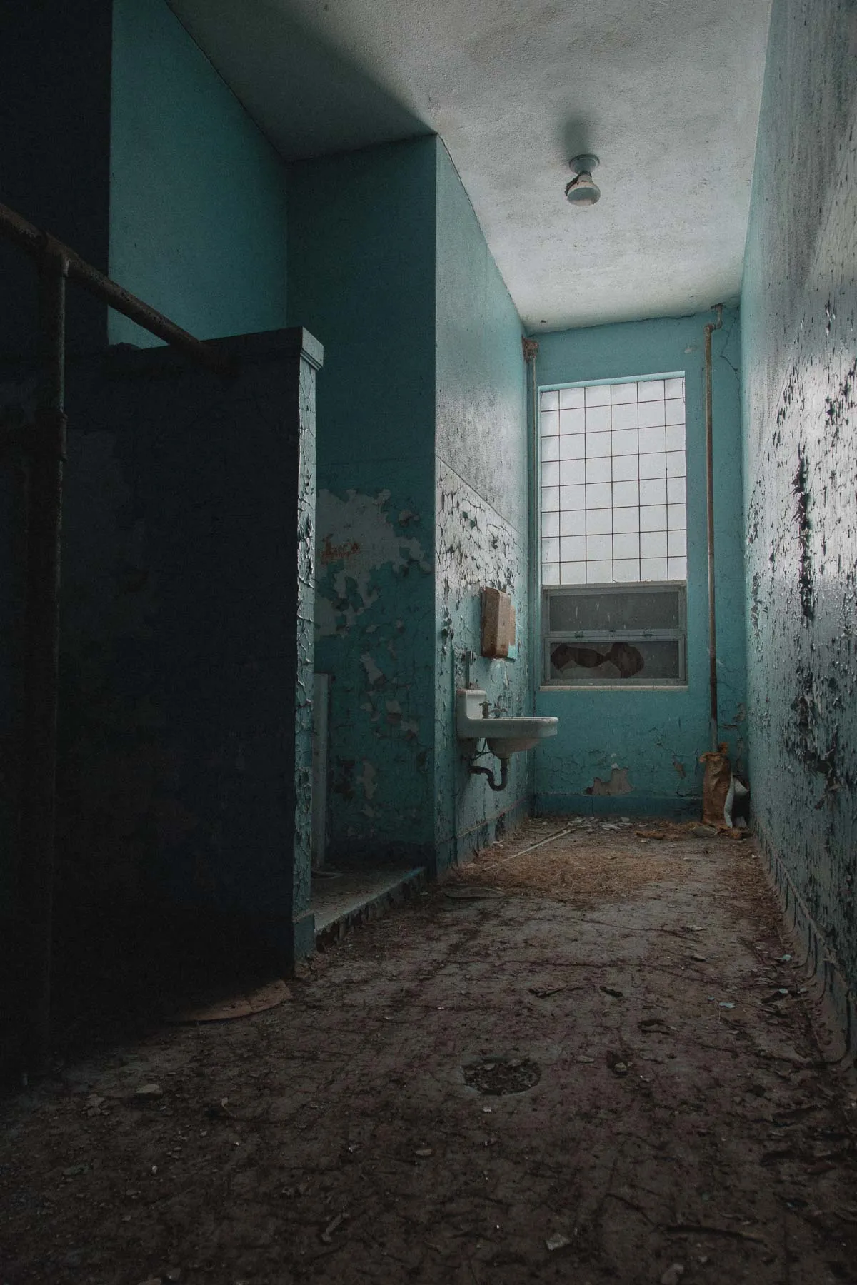 Utility sink at the end of the blue tiled bathroom in Ayrshire school