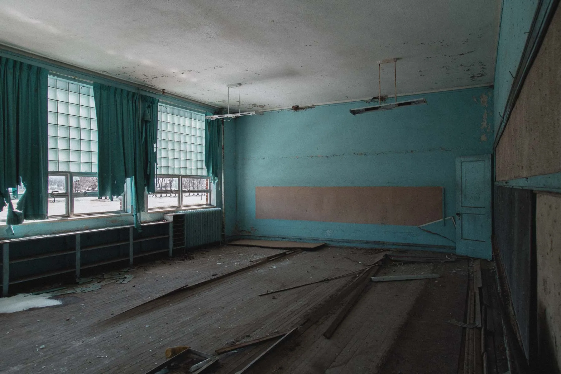 Blue classroom with wooden desks inside the abandoned Ayrshire school