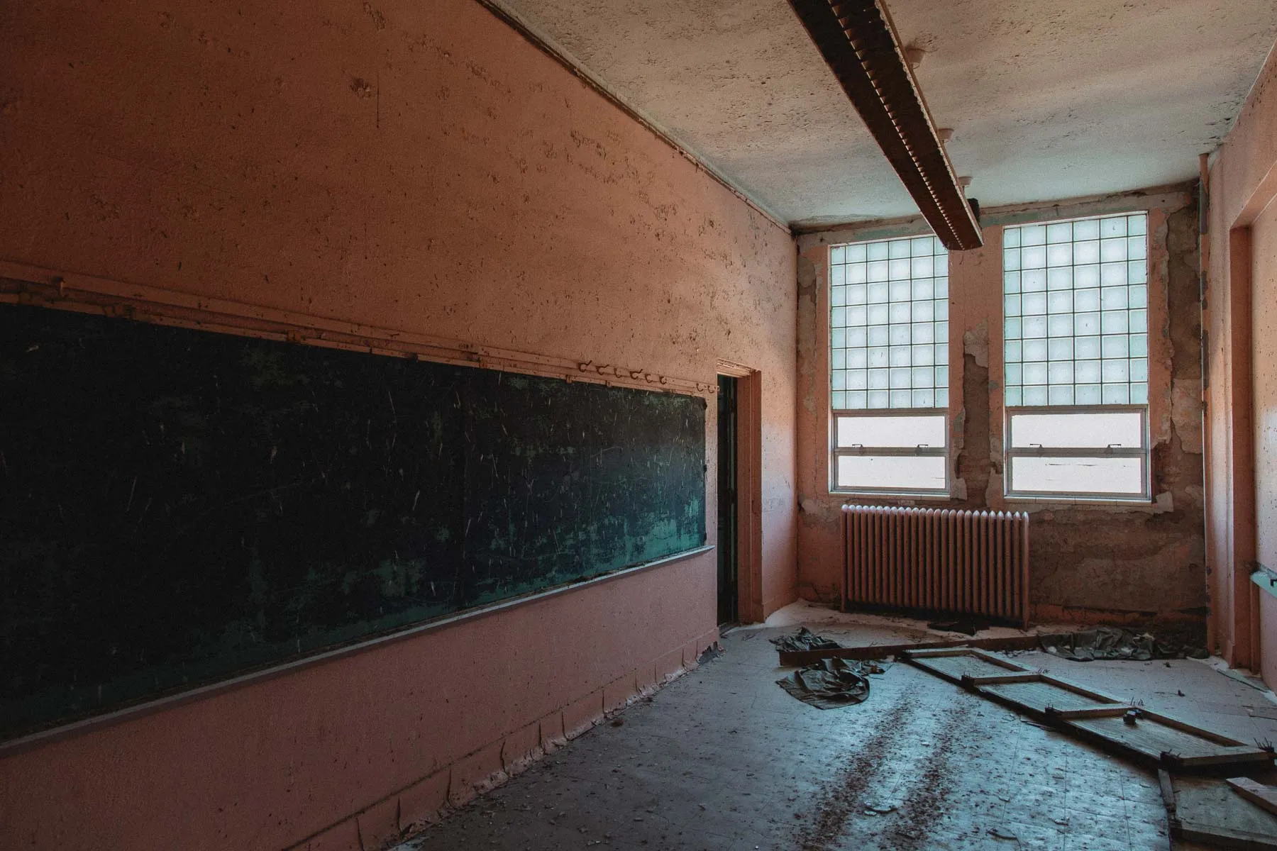 Coral-colored classroom chalkboard still covered in lessons