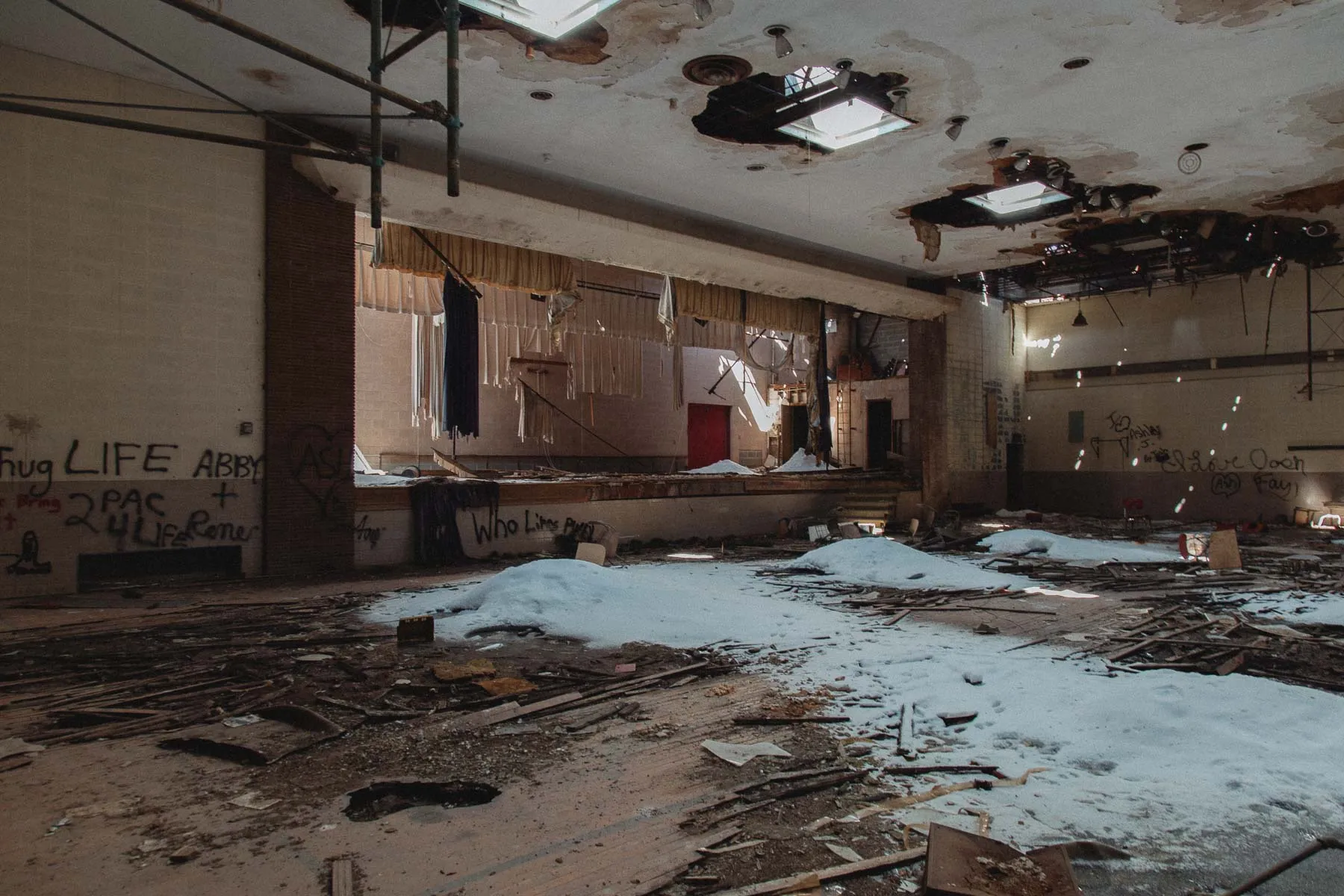 Faded green walls and basketball hoops inside Ayrshire school gymnasium