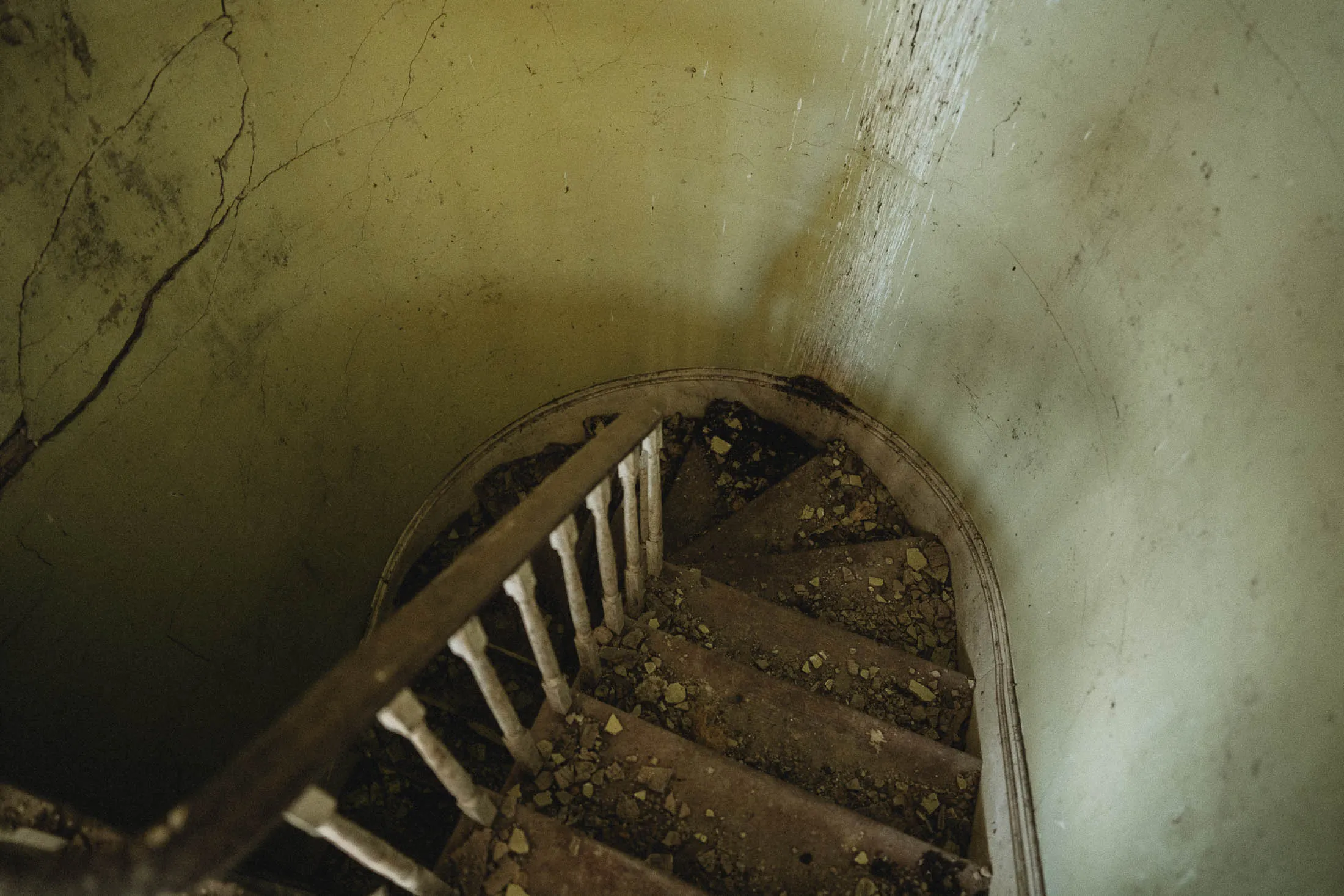 Half-turn staircase with cracked plaster walls, 1840s Greek Revival farmhouse