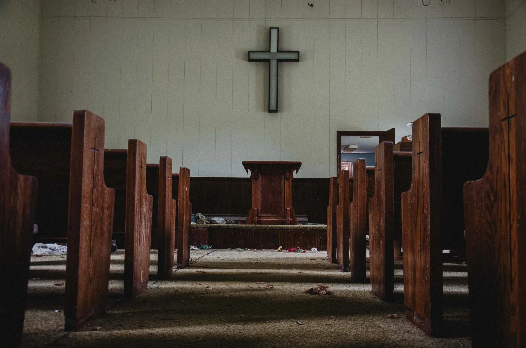 Pulpit and pews beneath a wooden cross inside Cadis Baptist Church
