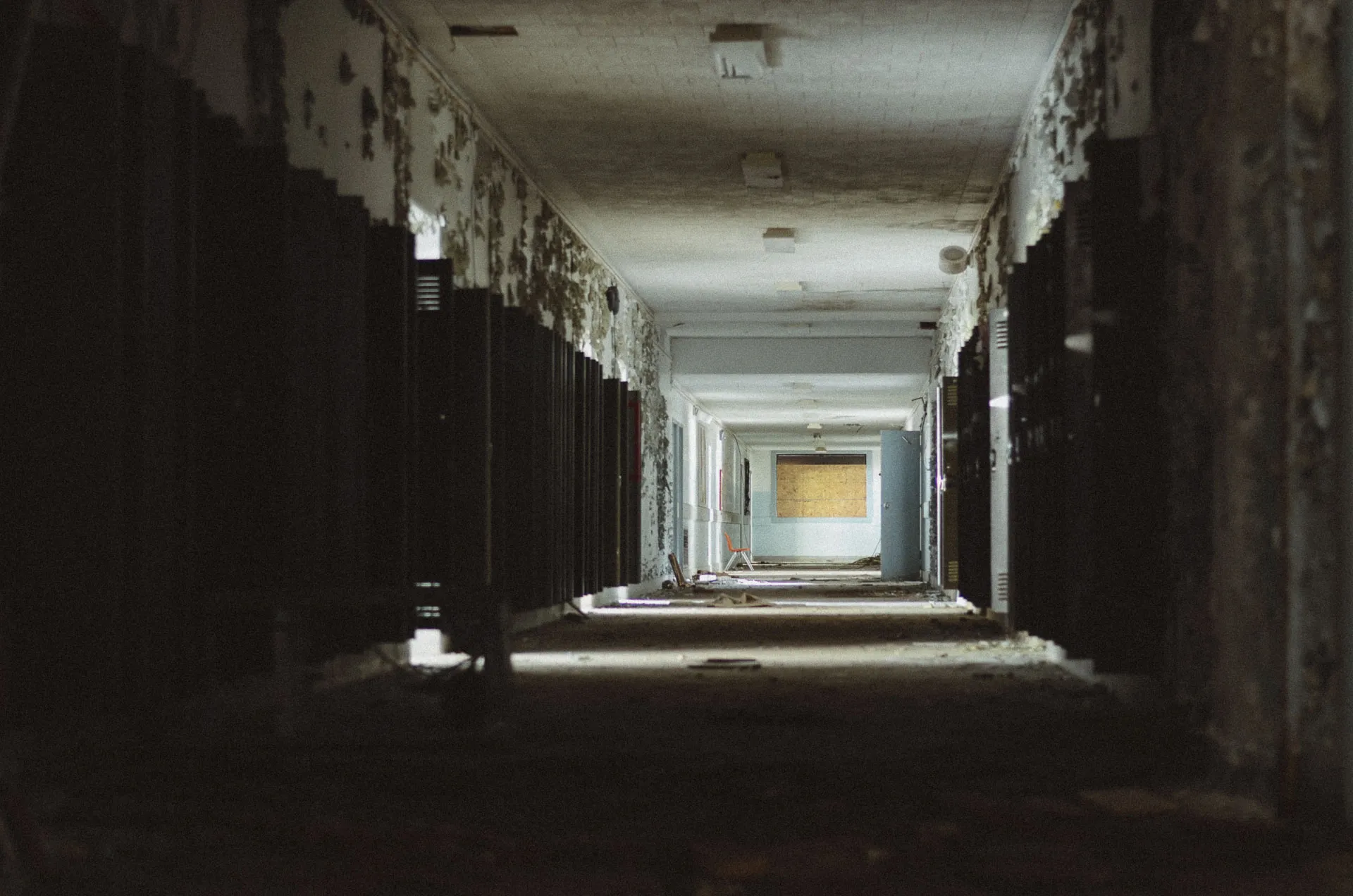 Sunlit first-floor hallway inside the abandoned Charlotte Kenyon Elementary School