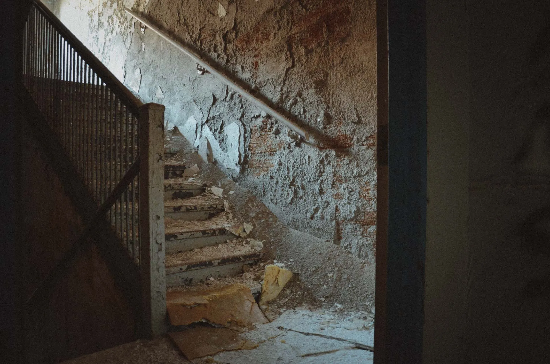 Peeling yellow paint along a stairwell inside Charlotte Kenyon Elementary School