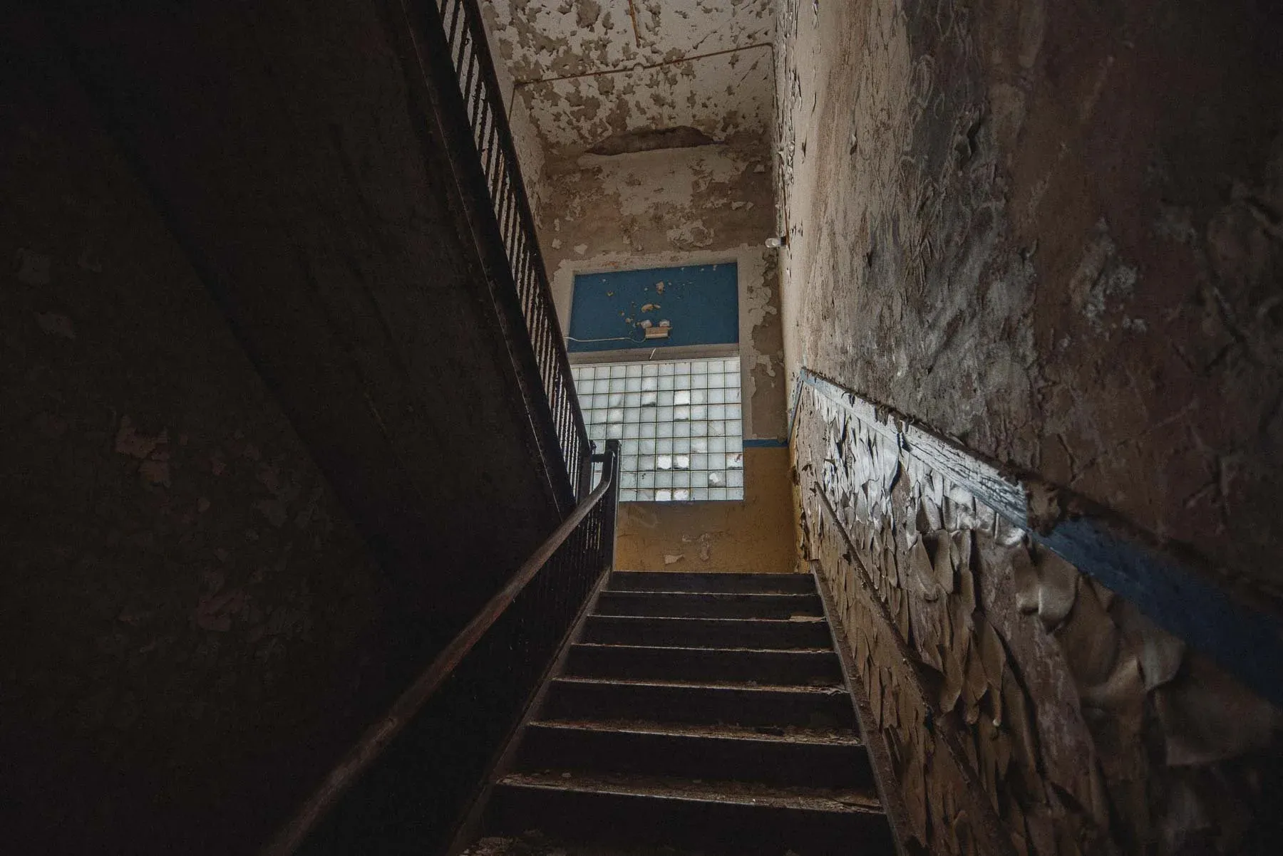 Blue and yellow stairwell inside the abandoned Columbus School in Rome, New York