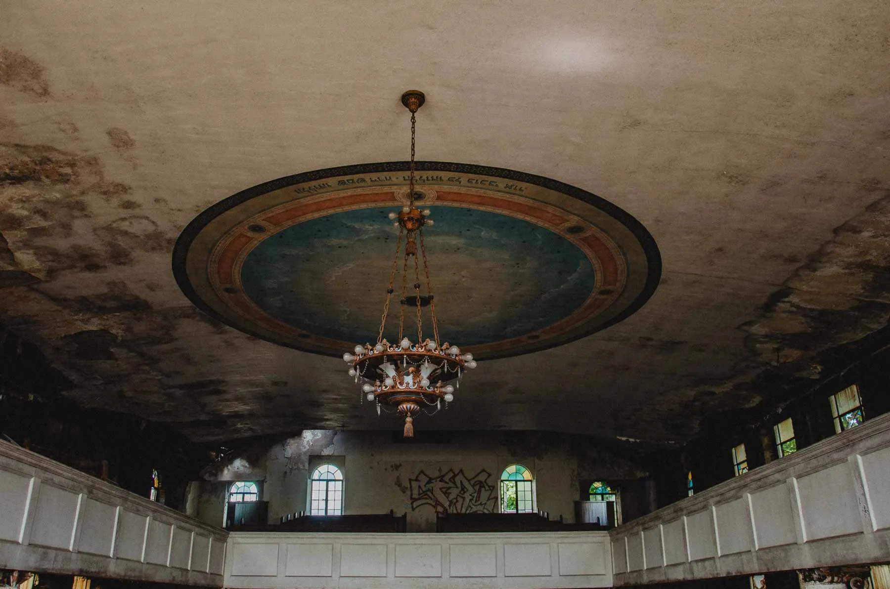 Chandelier hanging beneath a cracked plaster ceiling at Congregation B'Nai Israel