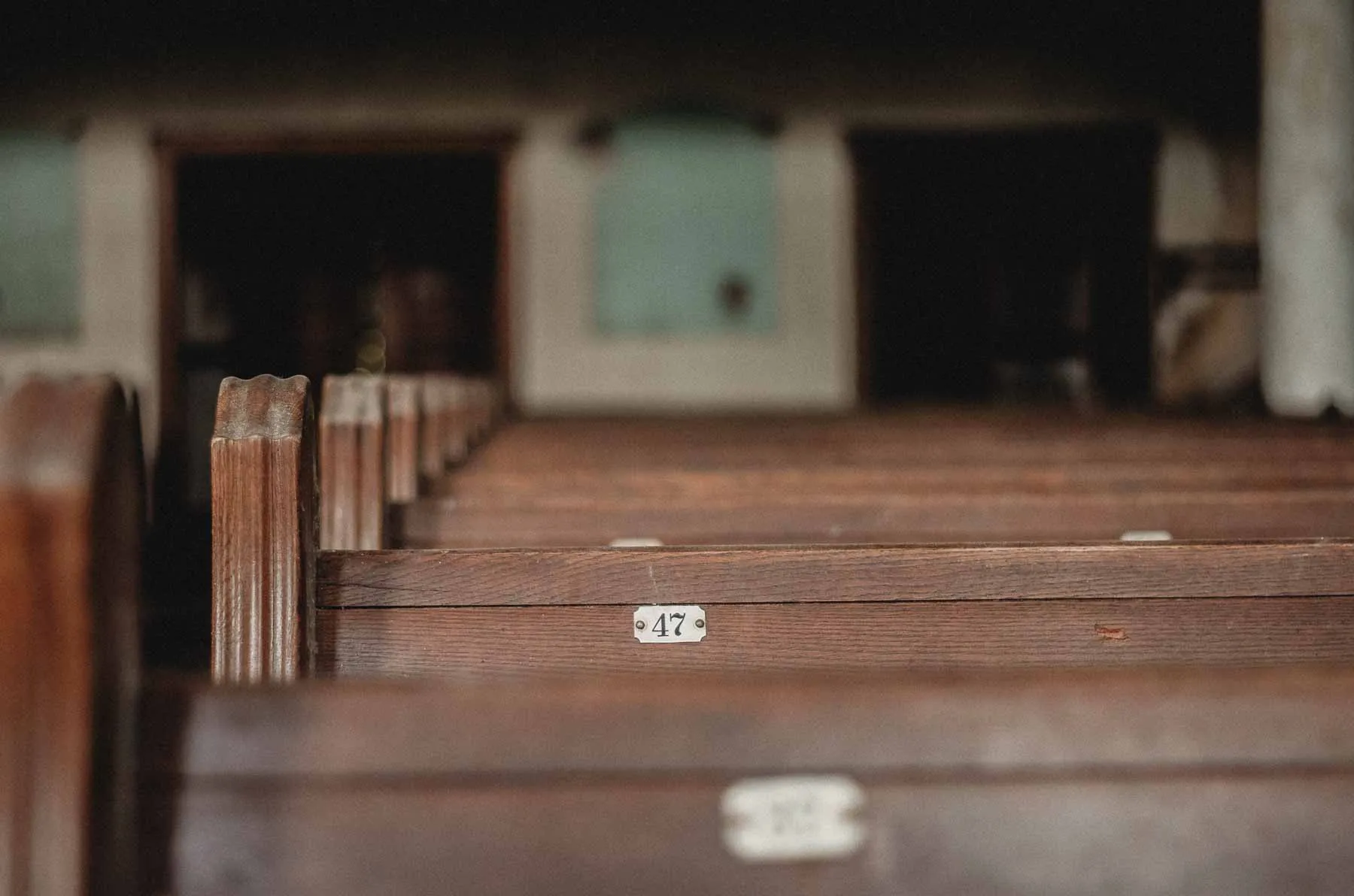 Numbered pew 47 with peeling paint inside the sanctuary
