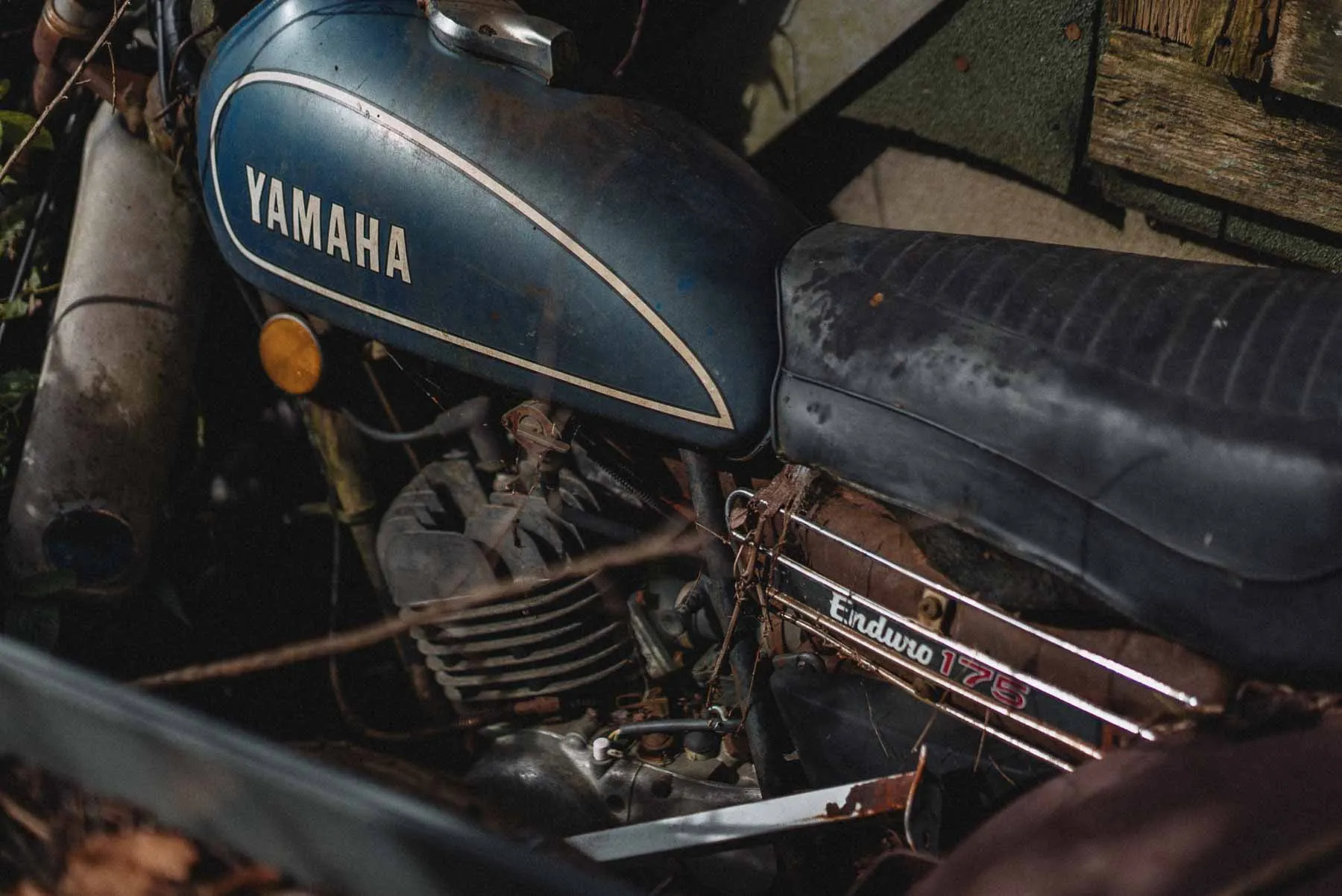 Abandoned Yamaha Enduro 175 motorcycle parked beside the Dog House barndominium in Owego NY