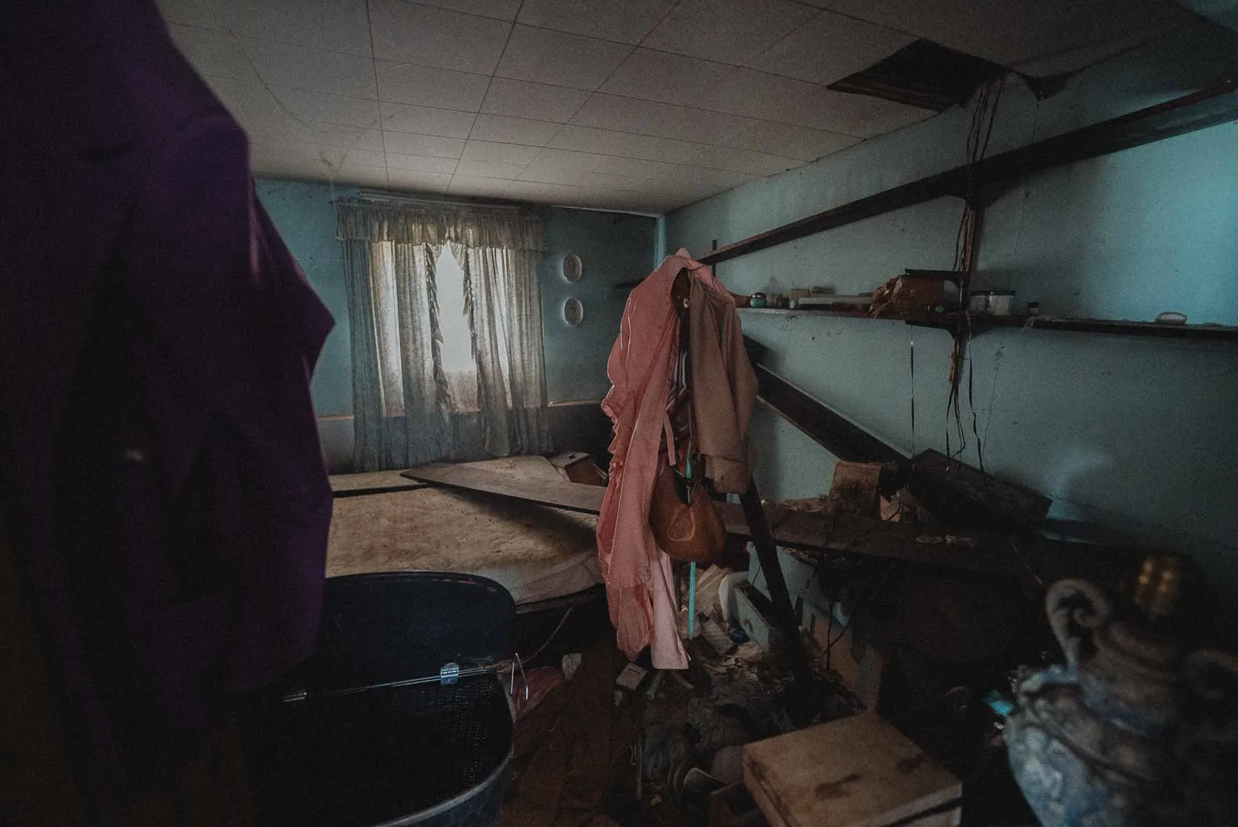 Blue bedroom with pink blouse and leather purse inside the Dog House barndominium, Southern Tier NY