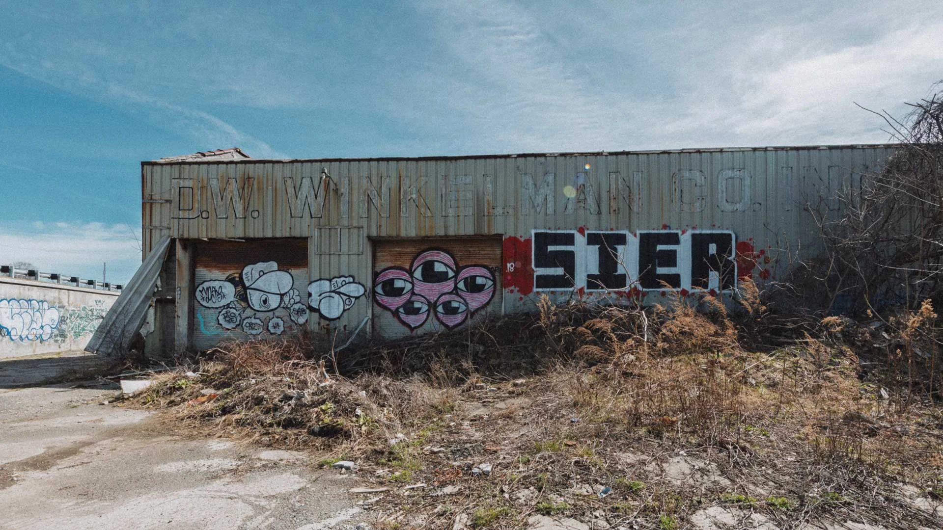 Exterior of the abandoned D.W. Winkelman Co. warehouse with painted logo in Syracuse, New York
