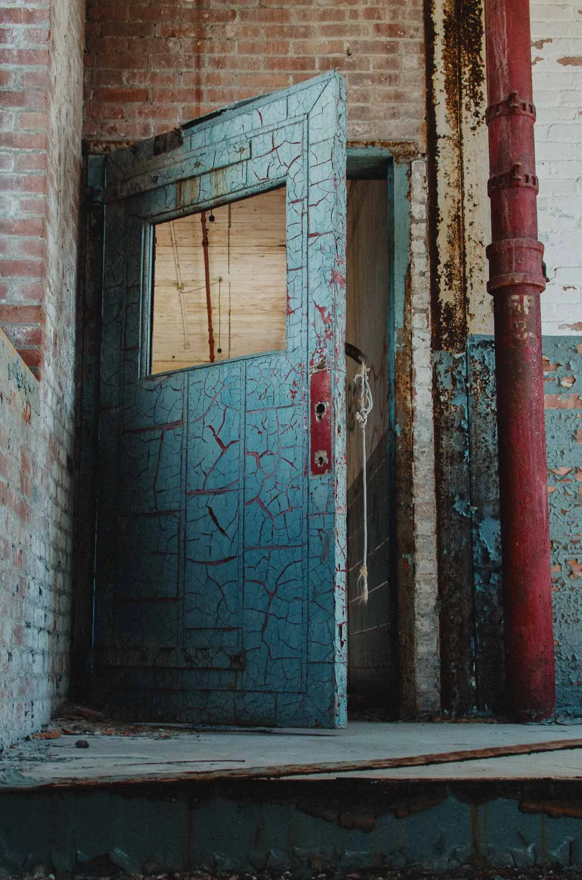 Fire-rated door with peeling paint and faded signage inside the Fair Play Factory