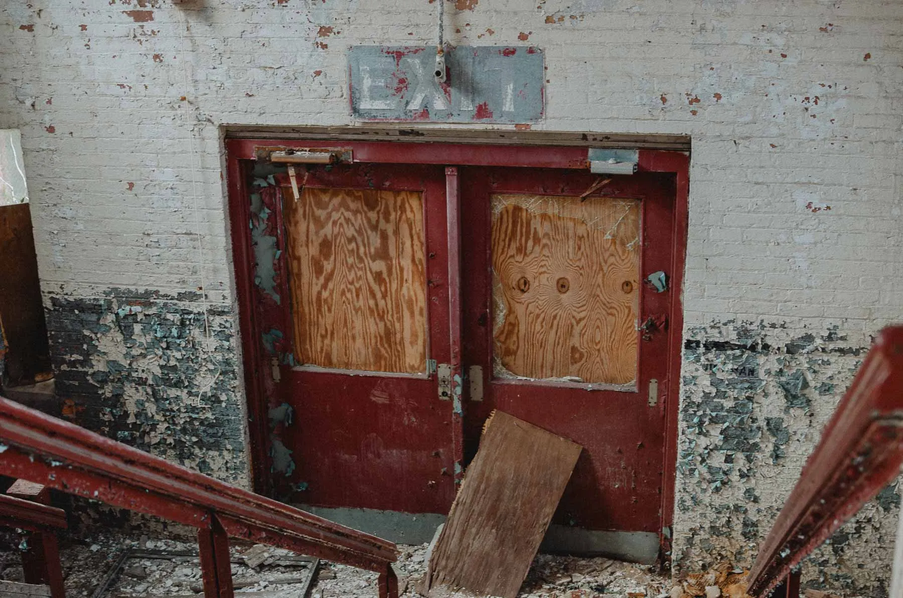 Red exit door and pendant lights inside the Fair Play Factory's main entrance foyer