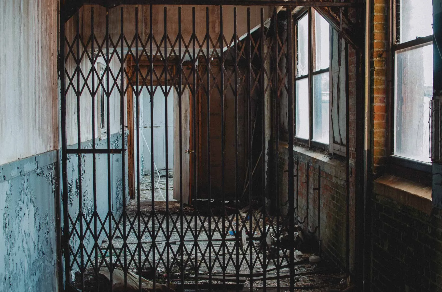 Retractable steel security gate at a corridor intersection inside the Fair Play Factory