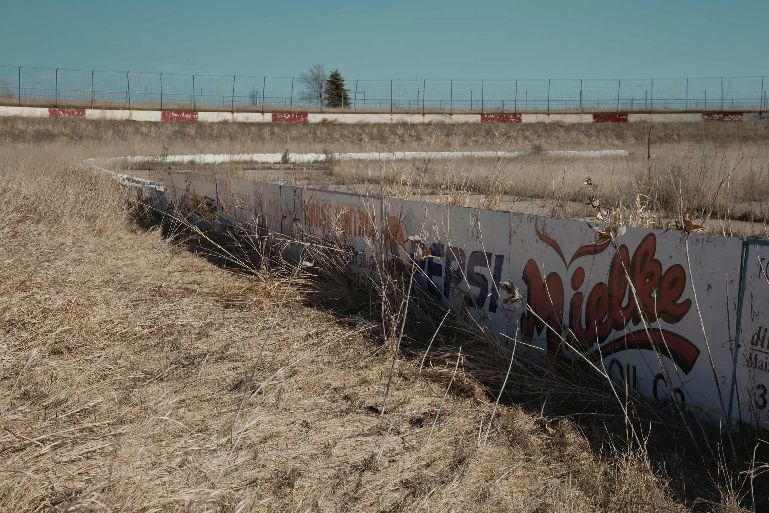Sun-faded sponsor advertising wall at I-94 Speedway