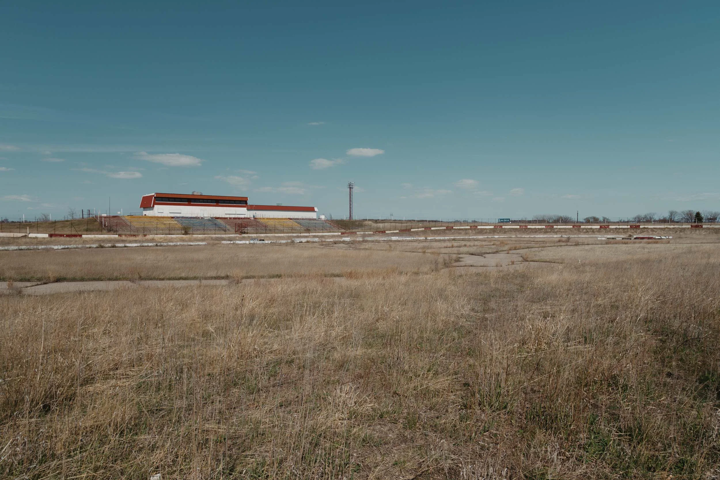 Weathered grandstands overlooking the abandoned I-94 Speedway oval