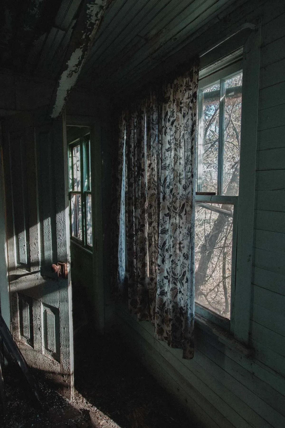 Floral curtains filtering light inside Landwehr Century Farm