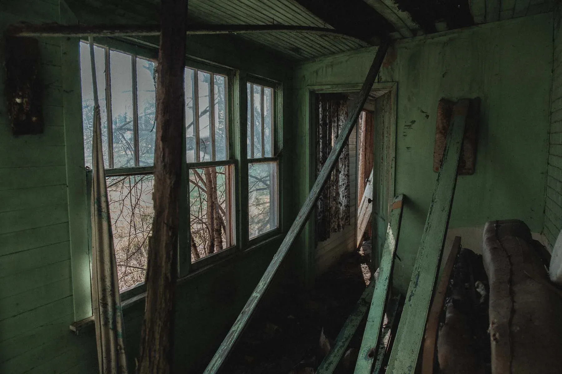 Green enclosed porch at the abandoned Landwehr Century Farm house