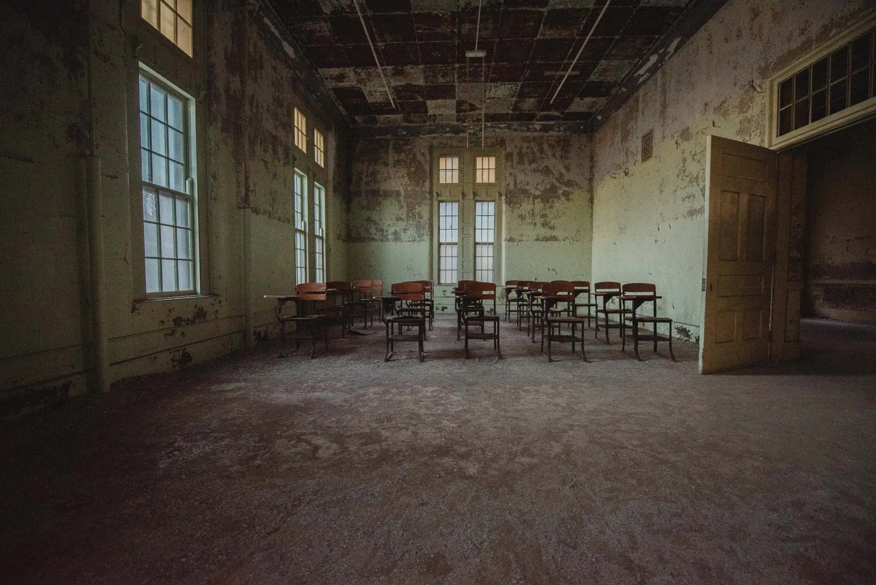 Green classroom with wooden desks inside the Richardson Olmsted Complex
